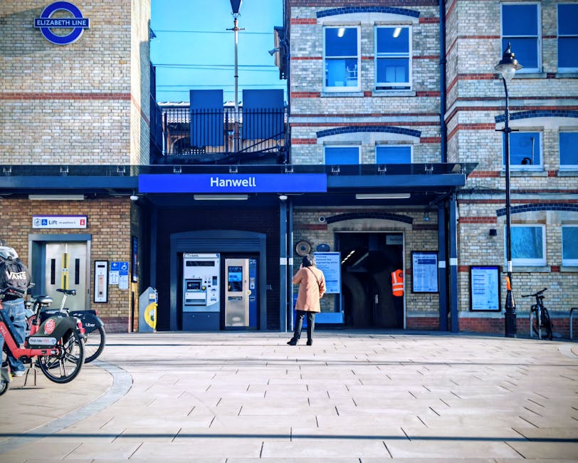 The image depicts Finsbury Park railway station platform with a large overhead canopy over the waiting area, supported by multiple vertical posts. In the foreground, several metal benches are arranged